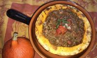 Готовое блюдо «Хоккайдская тыква с чечевицей и помидорами» в глиняной сковороде.