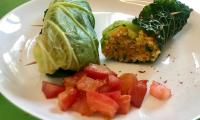Ready-made "Savoy cabbage rolls with Hokkaido and quinoa on tomato ragout", on a white plate.
