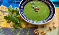 Готовый «Суп из зеленого горошка со шпинатом, петрушкой и грецкими орехами», в цветной тарелке.