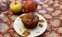 Una «Magdalena vegana de manzana y frutos secos sin aceite ni gluten» terminada en un plato blanco.