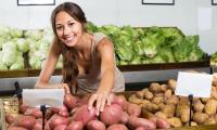 Zwei Sorten Kartoffeln - Solanum tuberosum: Eine Verkäuferin greift nach der roten Sorte. Es gibt je nach Zweck ganz unterschiedliche Sorten.