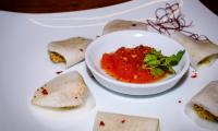 Ready-made "raw vegan kohlrabi tortellini with nut filling" on a white plate.