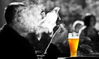 Thema warum Menschen Krebs bekommen: Raucher sitzt vor Alkohol.