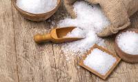 Sea salt in a burlap sack and wooden containers. Sea salt is produced from sea water collected in salt evaporation ponds. Sea salt does not contain iodine.