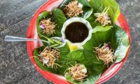 Miang kham sauce (separate recipe) in the center of a plate, surrounded by lettuce leaves.