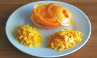 Orange peels on a plate. Different types of orange peels are shown here: intact (top), coarsely grated (right), and finely grated (left).