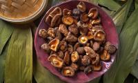 Сушеные грибы шиитаке - Lentinus edodes - на фиолетовой керамической тарелке.