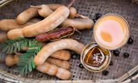 Tamarind (sweet), raw, in shell, peeled, scattered some tamarind seeds and juice.