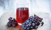 Traubensaft (hier mit Ascorbinsäure und Calcium zugesetzt) - Vitis vinifera: Glas mit rotem Saft.