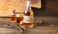 Natural vanilla extract - Vanilla planifolia: vials and vanilla pods next to it.