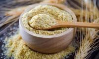 Wheat germ, raw: wooden bowl and wooden spoon with wheat germ, therefore wheat.