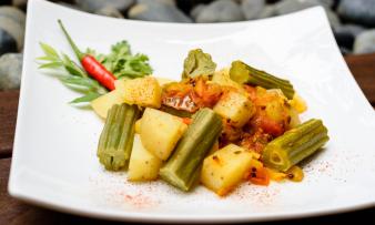 «Curry indio con vainas de moringa, patatas y tomate» terminado y servido en un plato. «Curry indio con vainas de moringa, patatas y tomate» terminado y servido en un plato.