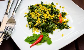 Fertig zubereitetes "Indisches Moringablätter-Curry mit Moong Dal und Kreuzkümmel", angerichtet auf einem Teller. Fertig zubereitetes "Indisches Moringablätter-Curry mit Moong Dal und Kreuzkümmel" auf Teller.