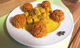 Il "Tempeh con curry all'arancia e riso speziato" è finito e servito su un piatto. Il "Tempeh con curry all'arancia e riso speziato" è finito e servito su un piatto.