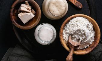 Hefe: links in frischen Blöcken, rechts als Pulver, beides in Holzschalen und essbar.